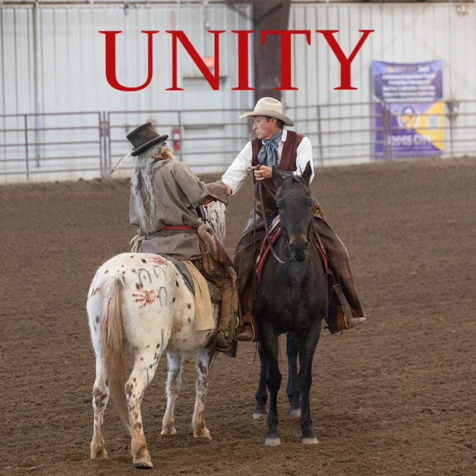 Mounted performers shaking hands in an arena under the word Unity