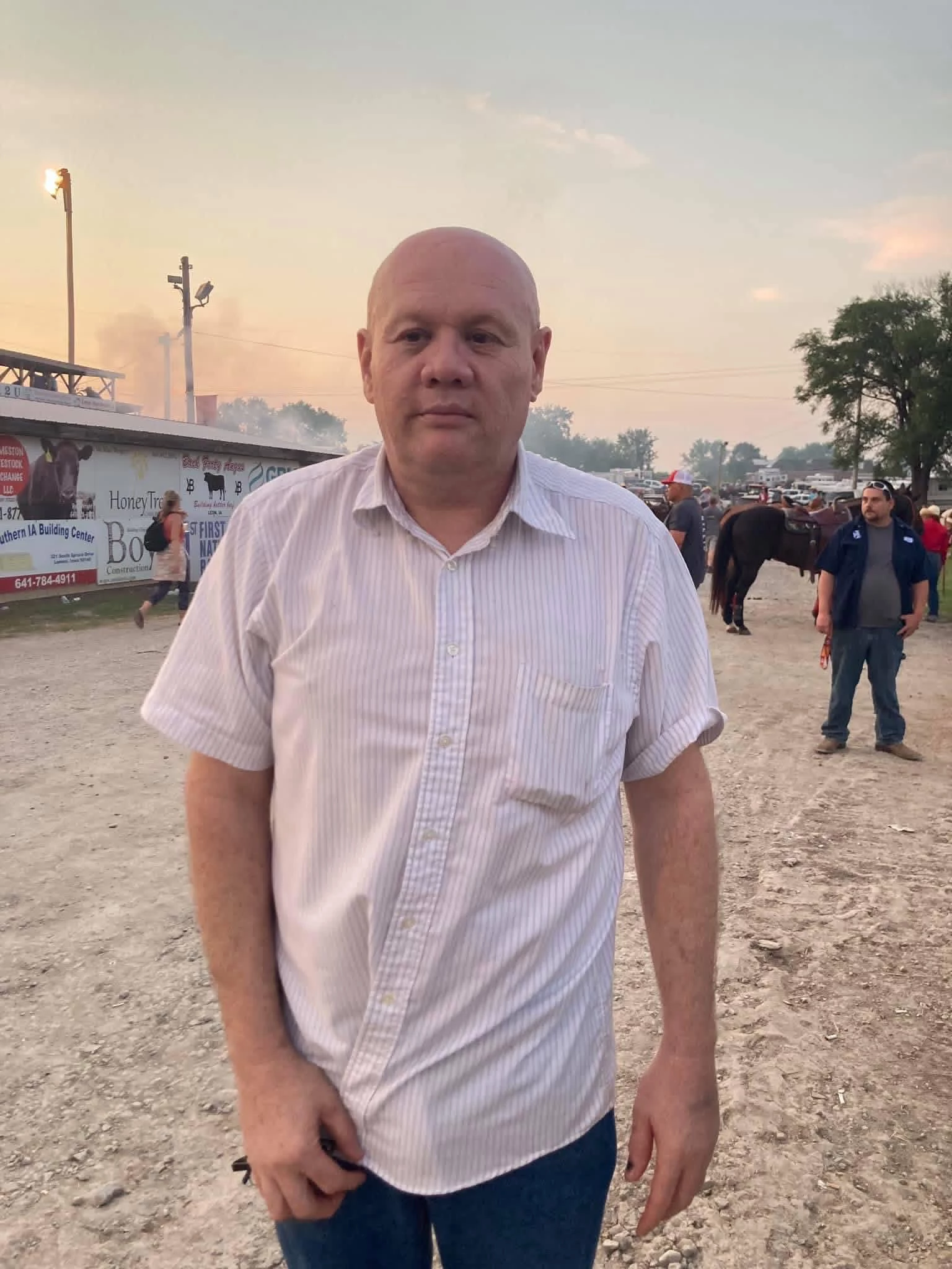 Kevin Browning standing at a rodeo grounds near horses and arena lights